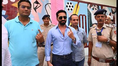 Actor Ayushmann Khurrana (centre) and former mayor Anup Gupta striking a pose after casting their votes at a polling booth in DAV School, Sector 8, in Chandigarh on Saturday. (Keshav Singh/HT)