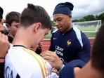 France's forward Kylian Mbappe (R) signs an autograph for a fan wearing a Real Madrid jersey France's forward Kylian Mbappe (R) signs an autograph for a fan wearing a Real Madrid jersey