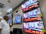 A man watching television waits for the release of exit polls published after voting concluded. (AFP)