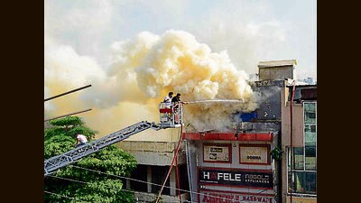 Fire officials work to douse the flames at a hardware showroom near Aarti Chowk in Ludhiana on Sunday. (Manish/HT)