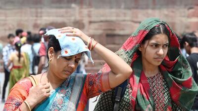 Visitors cover their head to shield themselves from heat near the Red Fort in Delhi. (Arvind Yadav/HT Photo)