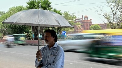 A man takes shelter under an umbrella during severe heatwave on a hot summer day in New Delhi on May 21, 2024. Indian authorities in the capital have ordered schools shut early for the summer holiday, after temperatures hit 47.4 degrees Celsius (117 degrees Fahrenheit) with Delhi gripped by a "severe heatwave". (Photo by Money SHARMA / AFP) (AFP) A man takes shelter under an umbrella during severe heatwave on a hot summer day in New Delhi on May 21, 2024. Indian authorities in the capital have ordered schools shut early for the summer holiday, after temperatures hit 47.4 degrees Celsius (117 degrees Fahrenheit) with Delhi gripped by a "severe heatwave". (Photo by Money SHARMA / AFP) (AFP)