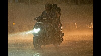 People make their way through a waterlogged road during heavy rainfall in Bengaluru. (AFP) People make their way through a waterlogged road during heavy rainfall in Bengaluru. (AFP)