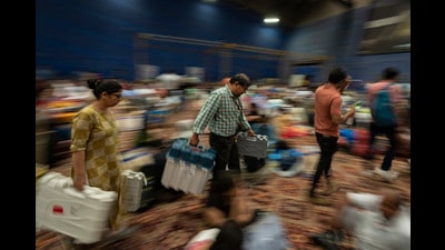 Polling officials carry electronic voting machines at a distribution centre (AP) Polling officials carry electronic voting machines at a distribution centre (AP)