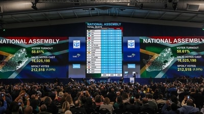 Guests and political party representatives use their mobile phones to record the electronic results board during the official announcement of the South African general election results in the Independent Electoral Commission (IEC) National Results Center at the Gallagher Convention Centre in Midrand, on June 2, 2024. South Africa's governing African National Congress (ANC) lost its 30-year-old outright majority in this week's election, winning only 159 seats in the 400-seat parliament, official results showed on June 2, 2024. (Photo by PHILL MAGAKOE / AFP) (AFP)