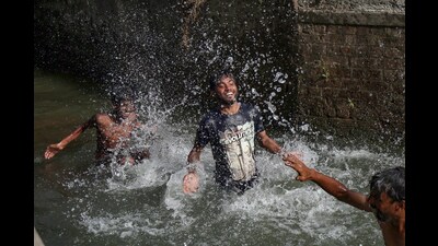 Youngsters taking a bath in a canal to cool off on a hot summer day, in Amritsar on Monday. (ANI)