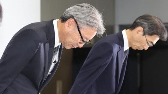 Honda Motor President and CEO Toshihiro Mibe (L) bows at the beginning of a press conference in Tokyo on June 3, 2024. Toyota said on June 3 it had suspended domestic shipments of three car models after falling foul of government certification rules along with its Japanese rivals Honda, Mazda, Suzuki and Yamaha. (Photo by JIJI Press / AFP) / Japan OUT (AFP)