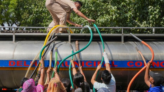 Residents fill water from a tanker amid water crisis, at the Vivekanand Camp in Chanakyapuri area of New Delhi, Friday, May 31, 2024. (PTI Photo/Kamal Singh)