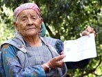 A 95-year-old, Budhi Devi, shows her voting slip as she arrives to cast her vote for the 2024 Lok Sabha elections, at a polling station in Kullu. (ANI FILE)