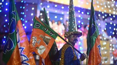 An artist wearing a costume holds a flag while waiting for the arrival of BJP leader during a roadshow (AFP FILE) An artist wearing a costume holds a flag while waiting for the arrival of BJP leader during a roadshow (AFP FILE)