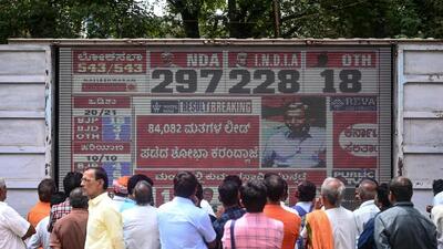 People watch the election results in Bengaluru. (AFP) People watch the election results in Bengaluru. (AFP)