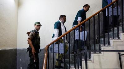 Police personnel escort election officials as they carry an EVM inside a counting centre in Delhi (REUTERS) Police personnel escort election officials as they carry an EVM inside a counting centre in Delhi (REUTERS)