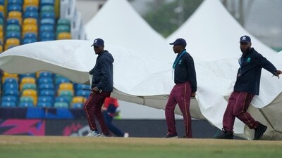 Ground staff cover the pitch as rains stops an ICC Men's T20 World Cup cricket match between England and Scotland' at Kensington Oval (AP) Ground staff cover the pitch as rains stops an ICC Men's T20 World Cup cricket match between England and Scotland' at Kensington Oval (AP)