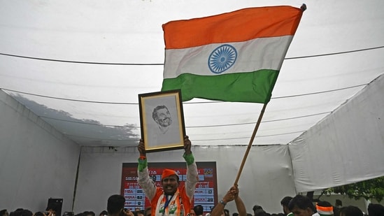Supporters of Indian National Congress (INC) party hold a portrait of their president Rahul Gandhi and wave India's national flag to celebrate vote counting results for the country's general election, at the INC headquarter in New Delhi on June 4, 2024. Vote counting was underway in India's election on June 4, with Prime Minister Narendra Modi all but assured a triumph for his Hindu nationalist agenda that has thrown the opposition into disarray and deepened concerns for minority rights. (Photo by Arun SANKAR / AFP) (AFP)