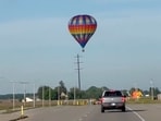 This photo provided by Debbie Wajvoda shows a hot air balloon crashing after hitting a utility pole on Sunday, June 2, 2024 east of Lowell, Ind.  Federal investigators are probing the crash in northwestern Indiana that injured three people. Firefighters responded to the crash and found the balloon in a bean field.  (Debbie Wajvoda via AP)