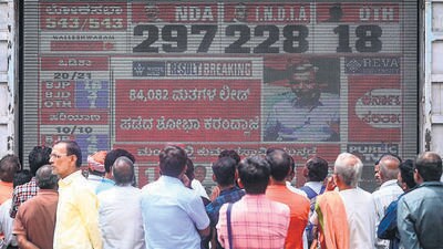 People watch the election results in Bengaluru on Tuesday. (AFP) People watch the election results in Bengaluru on Tuesday. (AFP)