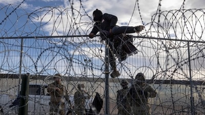 A migrant from Venezuela climbs over a border fence in an attempt to enter and seek asylum in El Paso, Texas, from Ciudad Juarez, Chihuahua, Mexico, on April 2, 2024. (Photo by CHRISTIAN MONTERROSA / AFP) (AFP) A migrant from Venezuela climbs over a border fence in an attempt to enter and seek asylum in El Paso, Texas, from Ciudad Juarez, Chihuahua, Mexico, on April 2, 2024. (Photo by CHRISTIAN MONTERROSA / AFP) (AFP)