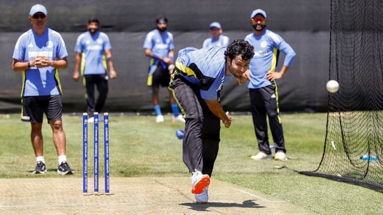 Shivam Dube bowls during a practice session as coach Rahul Dravid and teammates look on. (ANI)