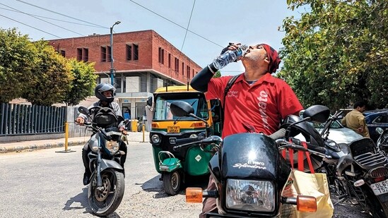 A Zomato delivery agent quenches his thirst before going on his delivery rounds (Anurag Mehra/HT)