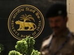 RBI MPC: A police officer walks past the Reserve Bank of India (RBI) logo inside its headquarters in Mumbai, India.