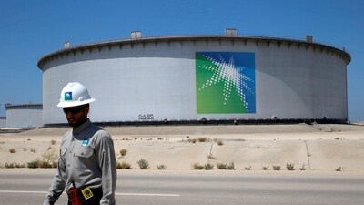 An Aramco employee walks near an oil tank at Saudi Aramco's Ras Tanura oil refinery and oil terminal in Saudi Arabia. (REUTERS)