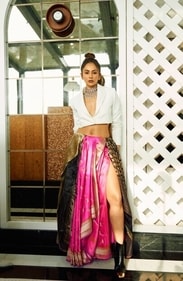 A perfect amalgamation of modernity and tradition, Rakul slays in this fusion look in a cropped blazer styled with three colourful Benarasi silk sarees in fuschia, zari and gharchola that have been styled into a skirt from Vidhi Singhania,a handloom brand known for its exquisite weaves. Her look has been further amped up with antique polki necklace with rose cut diamonds and pearls from The House of MBj. This look is perfect for the nonconformist brides. A perfect amalgamation of modernity and tradition, Rakul slays in this fusion look in a cropped blazer styled with three colourful Benarasi silk sarees in fuschia, zari and gharchola that have been styled into a skirt from Vidhi Singhania,a handloom brand known for its exquisite weaves. Her look has been further amped up with antique polki necklace with rose cut diamonds and pearls from The House of MBj. This look is perfect for the nonconformist brides.