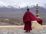 A Buddhist monk looks out to a snow-covered mountain range from Thiksay Monastery some 22 Km (13 miles) from Leh in the Indian Union territory of Ladakh on April 19, 2024. BUDDHISM (Photo by Mohd Arhaan ARCHER / AFP)