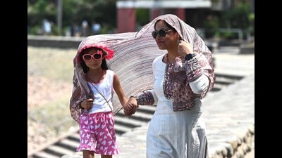 A mother and daughter duo shield themselves from hot weather at Sukhna Lake in Chandigarh on Friday. (Keshav Singh/HT)
