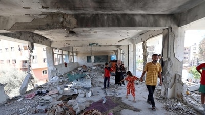 Members of a displaced family look at the damage to a school run by the UN Relief and Works Agency for Palestine Refugees (UNRWA) which was hit during an Israeli army strike the day before, in the Nuseirat camp in the central Gaza Strip on June 7, 2024, amid the ongoing conflict in the Palestinian territory between Israel and Hamas. (AFP) Members of a displaced family look at the damage to a school run by the UN Relief and Works Agency for Palestine Refugees (UNRWA) which was hit during an Israeli army strike the day before, in the Nuseirat camp in the central Gaza Strip on June 7, 2024, amid the ongoing conflict in the Palestinian territory between Israel and Hamas. (AFP)