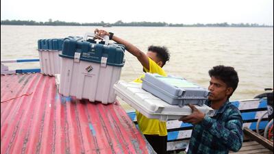 Polling officials carry EVMs on a boat to cross the Brahmaputra river in Kamrup, Assam. (ANI Photo)