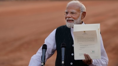 Indian Prime Minister-designate Narendra Modi displays a letter from the President of India, Draupadi Murmu, inviting him to form the next central government, outside the Rashtrapati Bhavan in New Delhi. (AP) Indian Prime Minister-designate Narendra Modi displays a letter from the President of India, Draupadi Murmu, inviting him to form the next central government, outside the Rashtrapati Bhavan in New Delhi. (AP)