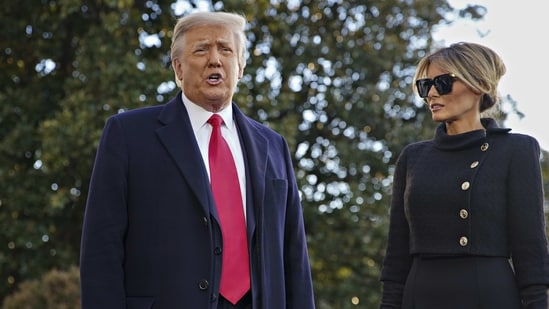 U.S. President Donald Trump speaks to members of the media next to U.S. First Lady Melania Trump, right, before boarding Marine One on the South Lawn of the White House in Washington, D.C., U.S., on Wednesday, Jan. 20, 2021. Trump departs Washington with Americans more politically divided and more likely to be out of work than when he arrived, while awaiting trial for his second impeachment - an ignominious end to one of the most turbulent presidencies in American history. Photographer: Al Drago/Bloomberg (Bloomberg)