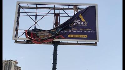 An illegal hoarding being taken down on the Dwarka Expressway near Sector-109 in Gurugram. (Parveen Kumar/HT PHOTO)