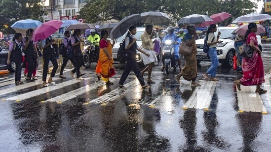 Kochi: Pedestrians hold umbrellas as they cross a street amid rains, in Kochi, Wednesday, May 29, 2024. India Meteorological Department (IMD) has forecasted very heavy rainfall in five districts of Kerala in the coming hours. (PTI Photo)