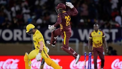 West Indies wicket keeper Nicholas Pooran jumps into the air in celebration as his teammate Akeal Hosein bowled out Uganda's Dineshkumar Nakrani, left, for a duck during an ICC Men's T20 World Cup cricket match at Guyana National Stadium (AP)