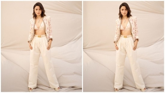 Her outfit, from the shelves of ace fashion designer Sabyasachi, features an off-white deep V-neck bralette adorned with a pink floral print. She paired it with high-waisted matching pants, accentuated by a statement Sabyasachi belt. Adding a touch of glamour, she completed the look with a matching full-sleeve jacket featuring embellished borders.(Instagram/@aliaabhatt)