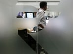 A currency trader is pictured through the symbol for the Indian Rupee on the floor of a trading firm in Mumbai.