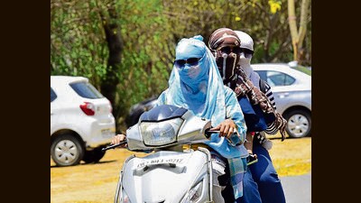 Students use scarves to protect themselves from the sun amid scorching heat at Punjab Agricultural University in Ludhiana on Tuesday. (Gurpreet Singh/HT)