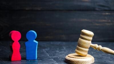 wooden figures of a man and a woman are standing near the judge's gavel. inequality concept : gender pay gap. divorce. Division of property in court. Social role in the family (Shutterstock) wooden figures of a man and a woman are standing near the judge's gavel. inequality concept : gender pay gap. divorce. Division of property in court. Social role in the family (Shutterstock)