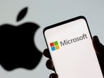 Microsoft logo is seen on the smartphone in front of displayed Apple logo in this illustration taken.
