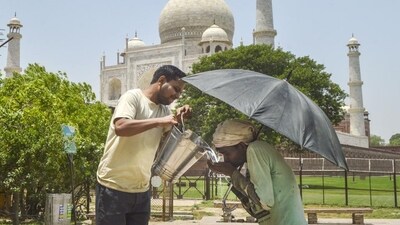 A man offers water to another on a hot summer day, near the Taj Mahal in Agra, on Wednesday. (PTI) A man offers water to another on a hot summer day, near the Taj Mahal in Agra, on Wednesday. (PTI)