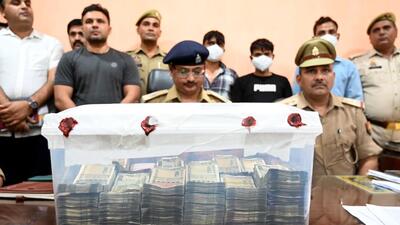 The suspects (standing behind) in police custody. Police also recovered the money from the arrested men. (Sunil Ghosh/HT Photo) The suspects (standing behind) in police custody. Police also recovered the money from the arrested men. (Sunil Ghosh/HT Photo)