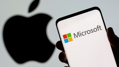 Microsoft logo is seen on the smartphone in front of displayed Apple logo in this illustration taken. (Reuters)