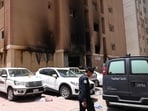 A member of the Kuwaiti security forces stands outside a building which was ingulfed by fire, in Kuwait City, on June 12. 