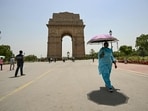 A woman holding an umbrella walks near the India Gate during severe heatwave on a hot summer day in New Delhi A woman holding an umbrella walks near the India Gate during severe heatwave on a hot summer day in New Delhi