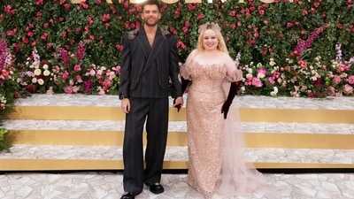 Nicola Coughlan and Luke Newton, the lead couple in Season 3, posed for the photocall during the London premiere. While Nicola chose a hand-beaded blush pink gown by Rodarte, Luke complemented her in a deep grey structured suit from the Emporio Armani Fall 2024 collection. He styled the embroidered, oversized jacket and pants set with chunky black boots, a trimmed beard, and a luxurious watch.&nbsp; (Scott A Garfitt/Invision/AP)
