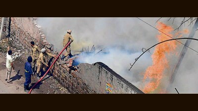 Firefighters trying to douse flames at the MC warehouse near Cheema Chowk in Ludhiana on Thursday. (Manish/HT)