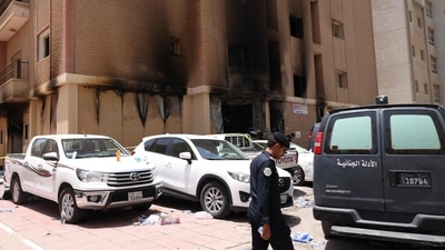 A member of the Kuwaiti security forces stands outside a building which was ingulfed by fire, in Kuwait City, on June 12. (AFP) A member of the Kuwaiti security forces stands outside a building which was ingulfed by fire, in Kuwait City, on June 12. (AFP)