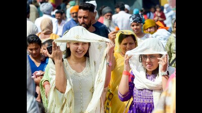 Women cover their heads for protection from scorching heat in the Heritage Street near Golden Temple in Amritsar on Thursday. (PTI) Women cover their heads for protection from scorching heat in the Heritage Street near Golden Temple in Amritsar on Thursday. (PTI)