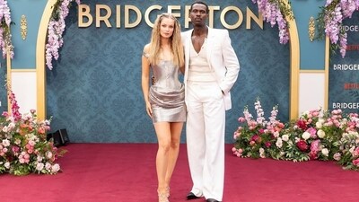 Hannah Dodd and Victor Alli pose on the red carpet at the Bridgerton Season 3 Part 2 premiere in London. While Hannah chose a metallic mini dress from Versace for the screening, Victor complemented her in an all-white suit by Alexander McQueen.&nbsp; (Instagram/@Netflix)